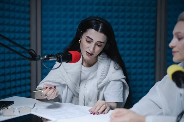 Two women hosting a radio show, using professional microphones in a soundproof studio. Before you brief radio advertising data protection, read this