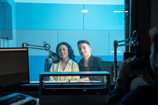 Two people in a radio studio broadcasting a show, featuring professional equipment and microphones with a blue theme. Why radio advertising risk scenarios deserve a place in your plan