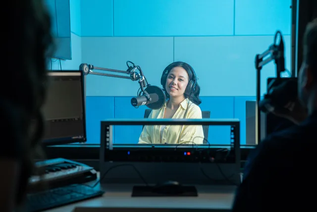 A podcast host records a show in a professional radio studio with microphones and headphones. Set radio advertising service standards without slowing your team down