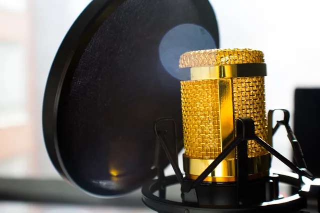 Close-up of a gold studio microphone with pop filter, ideal for recording and broadcasting. Before you commit budget, check these radio advertising strategy mistakes