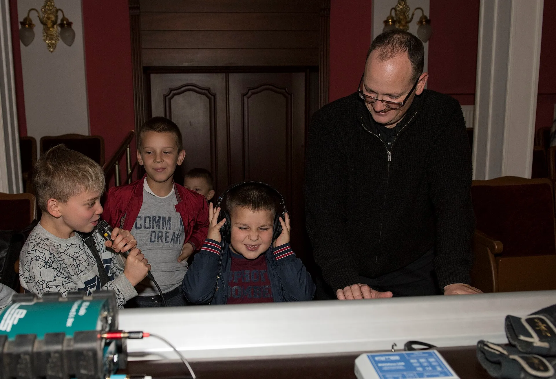 U.S. Air Force Senior Airman Warren Lynch, U.S. Air Forces in Europe Ambassadors Jazz Band audio engineer, gives local music students control over the headphones and shows them control switches between voice and music sound, during a master class with the USAFE Band and the Ukrainian National Presid